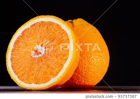 Half an orange. Two halves of fruit on a wooden table. Copyspace. Half an orange. Two halves of fruit on a wooden table. Copyspace. 93737387