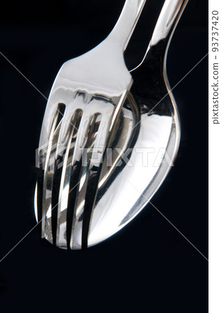 spoon and fork in black background spoon and fork in black background 93737420