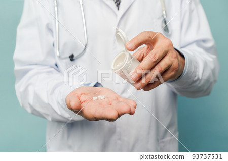 Doctor pouring pills on his palm 93737531