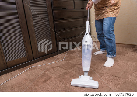 [Middle housewife cleaning carpet with a handy cleaner] 93737629