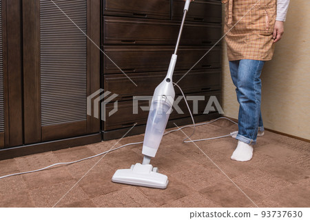 [Middle housewife cleaning carpet with a handy cleaner] 93737630