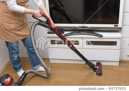 [Middle housewife cleaning flooring with a cyclone cleaner] 93737633