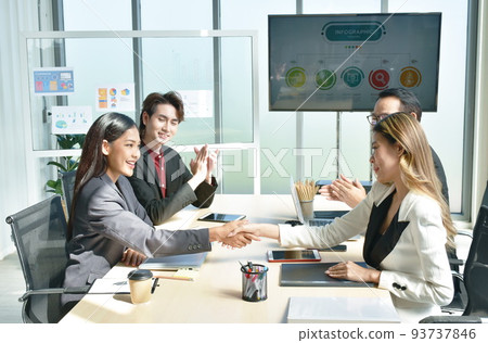 Asian business women shaking hand together after meeting with success and win deal in office room Asian business women shaking hand together after meeting with success and win deal in office room 93737846