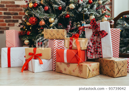 Multicolored gifts under the Christmas tree photo close-up New Year's Eve, multicolored gifts, red and gray and black Multicolored gifts under the Christmas tree photo close-up New Year's Eve, multicolored gifts, red and gray and black 93739042
