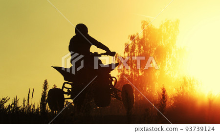 Quad biker jumping in sunset. 93739124
