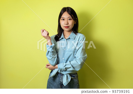 Japanese Millennial Lady Posing Looking At Camera Over Yellow Background 93739191