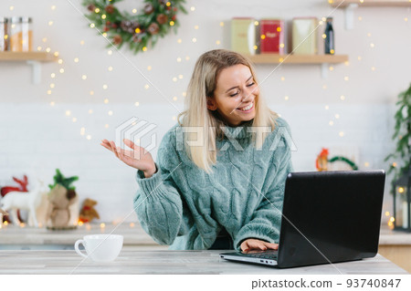 Business woman working at home on laptop during Christmas and New Year, happy and successful making a video call to colleagues and friends 93740847