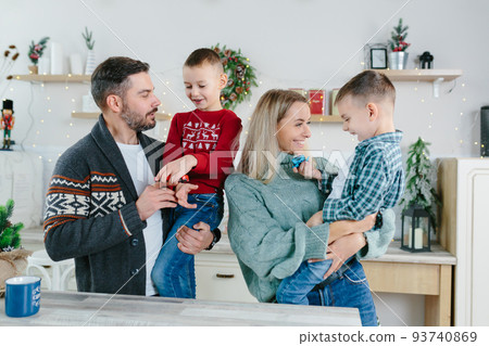 Cheerful happy married couple with two children waving hands laughing having fun at home for Christmas posing to camera indoor modern technology New Year congratulations to family or friends. Cheerful happy married couple with two children waving hands laughing having fun at home for Christmas posing to camera indoor modern technology New Year congratulations to family or friends. 93740869