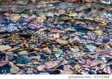 Rainbow multi-colored rocks in Avalanche creek leading towards Lake McDonald at Glacier National Park, Montana, USA 93741668