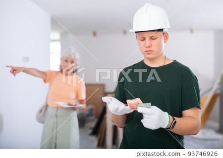 Teenager construction worker dissatisfied with small salary 93746926
