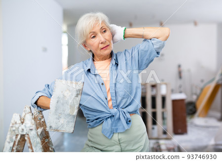 Portrait of positive woman with spatula in her hand in room being renovated 93746930