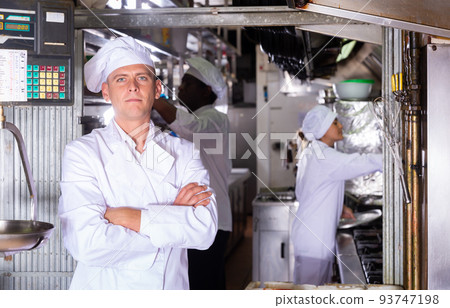 portrait of adult happy male cook standing in restaurante portrait of adult happy male cook standing in restaurante 93747198