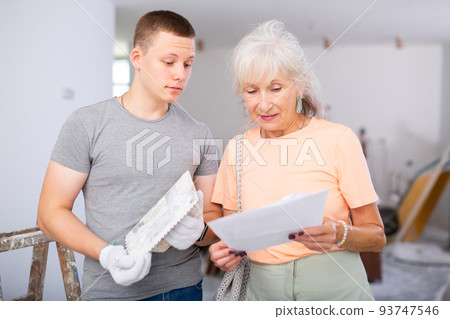 Teenager helping senior woman with home improvement works Teenager helping senior woman with home improvement works 93747546