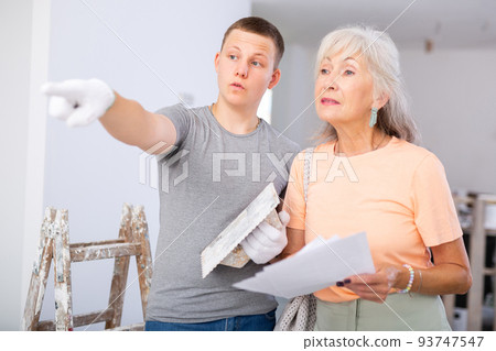 Woman talking with teenager on construction site Woman talking with teenager on construction site 93747547