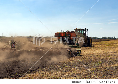 The tractor plows the land. Agriculture image. The tractor plows the land. Agriculture image. 93748575