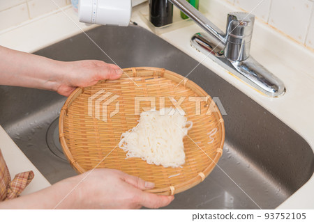 [Middle housewife cools somen noodles with running water and then drains them] 93752105
