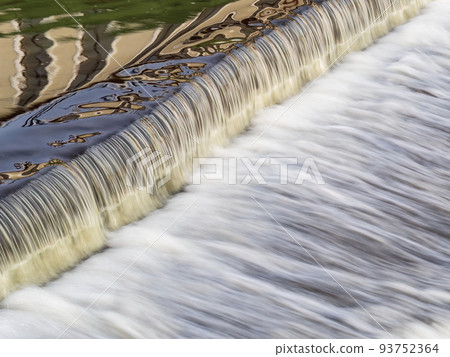 A small flat cascade in a calm river A small flat cascade in a calm river 93752364