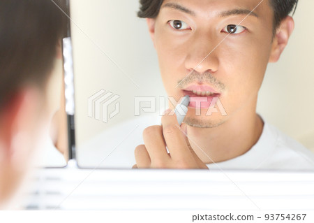 照鏡子塗潤唇膏的男人男人的美麗形象 93754267