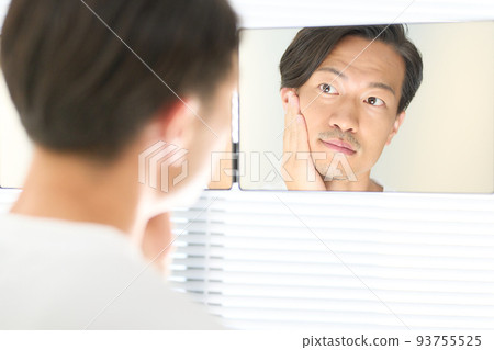 照鏡子時把手放在下巴上的年輕人 93755525
