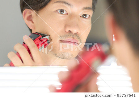 年輕人用剃須刀刮鬍子的男士美容形象 93757641