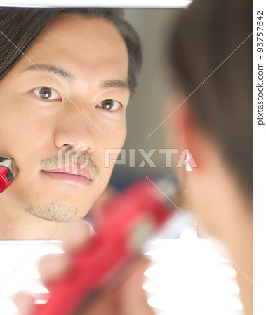年輕人用剃須刀刮鬍子的男士美容形象 93757642