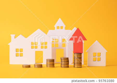 Coins on a table, a red up arrow and house. The concept of the rising price of real estate 93761080
