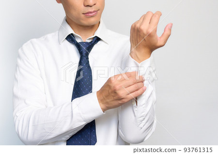 Businessman changing clothes to fasten sleeve buttons Businessman changing clothes to fasten sleeve buttons 93761315