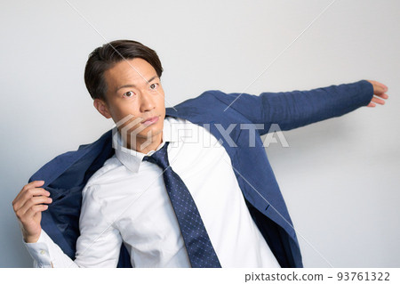 A businessman who puts his sleeves through his jacket while spreading his hands 93761322