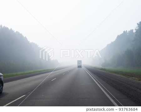 haze on road from burning forest smoke in morning 93763684