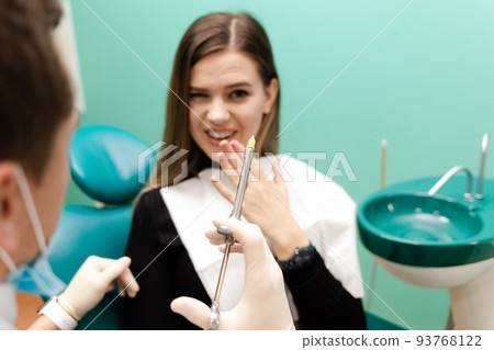 Dentist doctor holds an injection syringe. Girl has to make an analgesic injection. Woman is afraid of injections concept. Injection pen close-up Dentist doctor holds an injection syringe. Girl has to make an analgesic injection. Woman is afraid of injections concept. Injection pen close-up 93768122