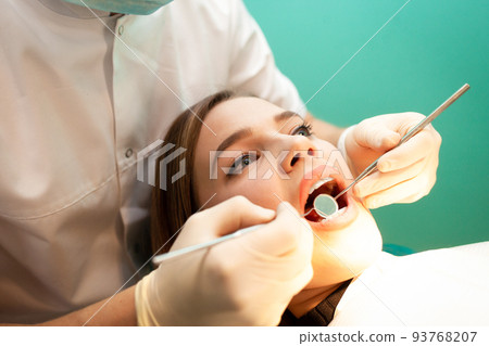 Young woman came to the dentist for examination. The dental doctor examines the patient close-up.. Young woman came to the dentist for examination. The dental doctor examines the patient close-up.. 93768207