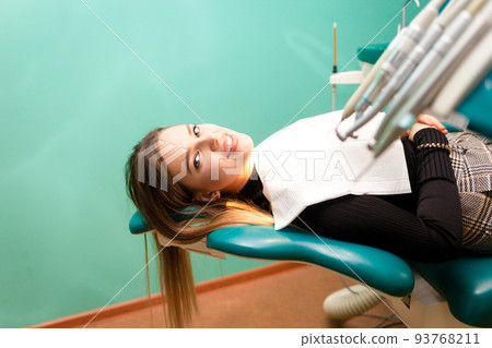 Girl sitting on a dental chair waiting for procedures.. 93768211