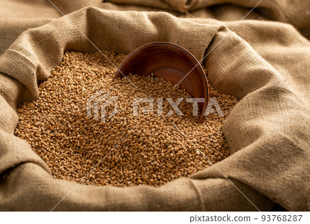 Burlap sack with wheat grains and clay bowl Burlap sack with wheat grains and clay bowl 93768287