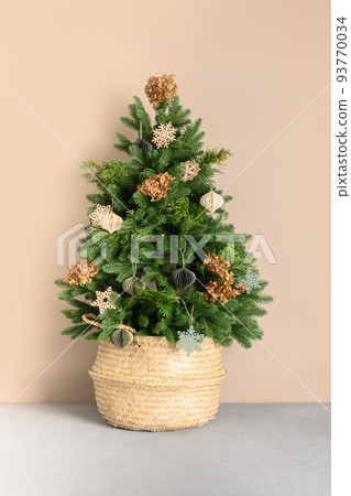 Christmas tree in wicker basket decorated with natural dry flowers and eco materials, DIY toys. 93770034