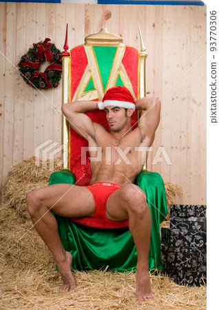 Sexy and muscled santa claus man in his armchair Sexy and muscled santa claus man in his armchair 93770306
