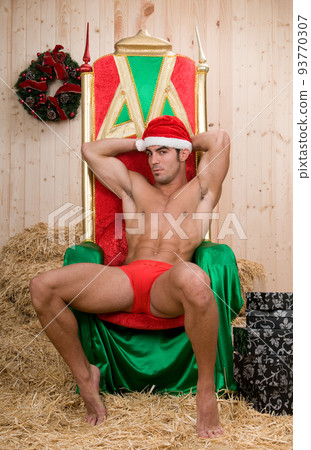 Sexy and muscled santa claus man in his armchair Sexy and muscled santa claus man in his armchair 93770307