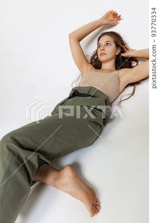 Portrait of young pretty girl with long hair posing isolated over gray studio background. Wellness, wellbeing, bodypositive, fashion concept. Portrait of young pretty girl with long hair posing isolated over gray studio background. Wellness, wellbeing, bodypositive, fashion concept. 93770334