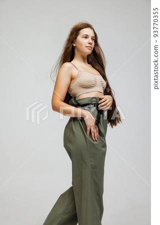 Portrait of young pretty girl with long hair posing isolated over gray studio background. Wellness, wellbeing, bodypositive, fashion concept. Portrait of young pretty girl with long hair posing isolated over gray studio background. Wellness, wellbeing, bodypositive, fashion concept. 93770355