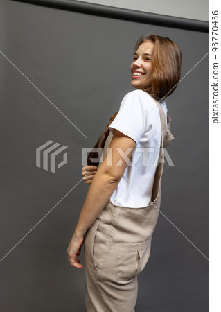 Young charming girl with long hair in casual style clothes posing isolated over dark grey background. Youth, fashion, happiness concept. 93770436