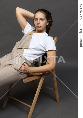 Young charming girl with long hair in casual style clothes posing isolated over dark grey background. Youth, fashion, happiness concept. Young charming girl with long hair in casual style clothes posing isolated over dark grey background. Youth, fashion, happiness concept. 93770475