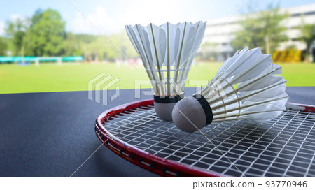 Badminton shuttercocks on raquettes are on dark background 93770946