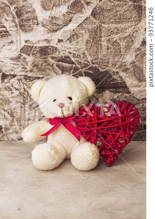 White Teddy bear with red heart on grey wall background White Teddy bear with red heart on grey wall background 93771246