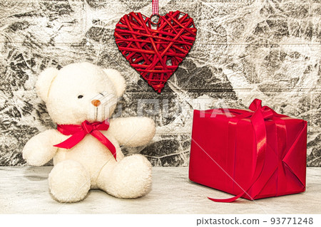 White Teddy bear with red heart and gift box on grey wall background White Teddy bear with red heart and gift box on grey wall background 93771248
