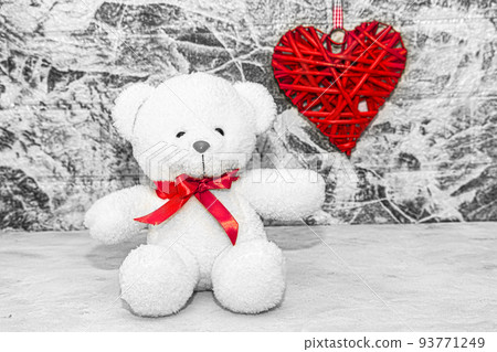 White Teddy bear with red heart on grey wall background White Teddy bear with red heart on grey wall background 93771249