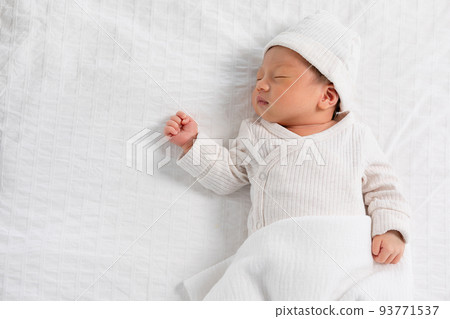 Top view happy newborn baby lying sleeps on a white blanket comfortable and safety at warmth place. Cute Asian newborn sleeping and napping on bed. Newborn Baby Care concept 93771537