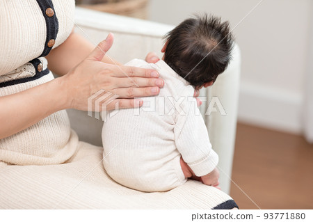 Mother take care her newborn baby hiccups to burp the baby may reduce air in stomach.Newborn baby hiccups after over feeding milk.Newborn Baby Health Care Concept 93771880