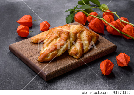 Delicious fresh cornmeal pastries with homemade cheese on a wooden cutting board Delicious fresh cornmeal pastries with homemade cheese on a wooden cutting board 93773392
