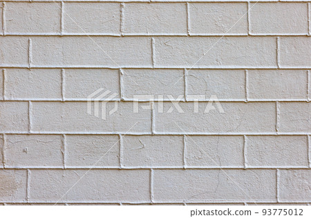 Texture of a plastered beige brick wall with exposed cement joints. 93775012