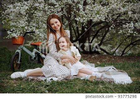 Mom and daughter walk on bicycles 93775298