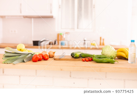 Vegetables and fruits. Onion, tomato, pepper, banana on wooden table in kitchen Vegetables and fruits. Onion, tomato, pepper, banana on wooden table in kitchen 93775425